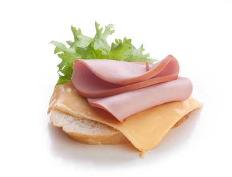 Sandwich with cooked sausage, processed cheese, green lettuce and loaf