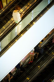 Bangkok, Thailand - September 12, 2013: Shoppers on escalator at Terminal21 shopping mall on September 12, 2013. Terminal21 is a new shopping mall in the Asok district in Bangkok, Thailand