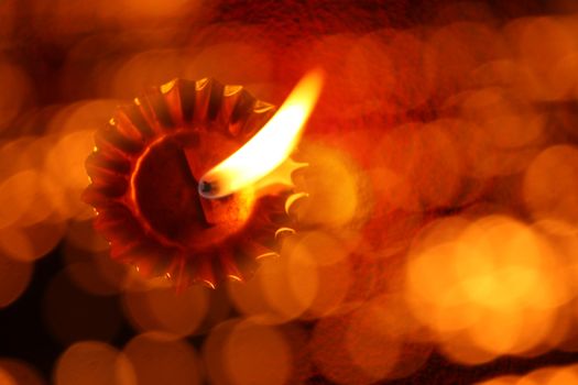 A unique traditional Diwali lamp image with an abstract view of a lit lamp through a line of blur lights