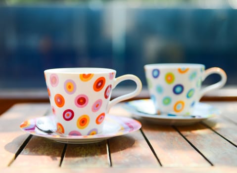 Colorful cup of coffee on wooden table 