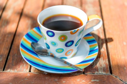 Colorful cup of coffee on wooden table 