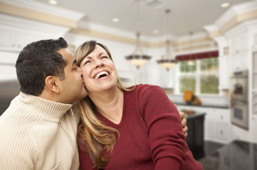 Happy Mixed Race Couple Kissing Inside Beautiful Custom Kitchen.