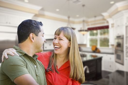 Happy Mixed Race Couple Inside Beautiful Custom Kitchen.