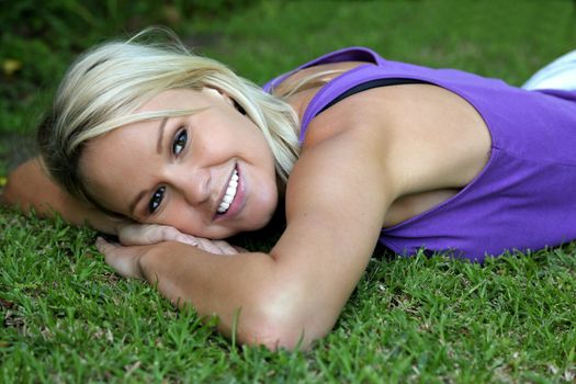 Gorgeous blond lady relaxing on the green grass