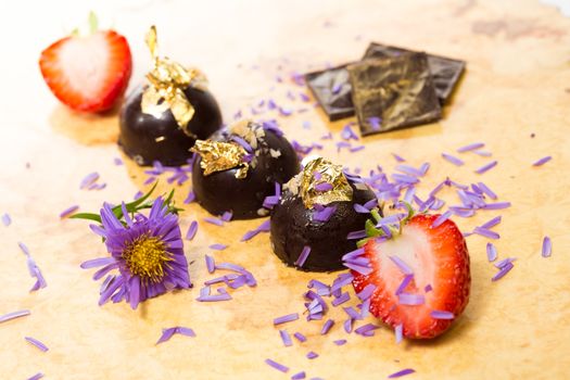 dark chocolate on a wooden table. Decorated with gold leaf. selective Focus