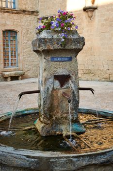 Ancient fountain on the central square of Grambois village, Provence, South France