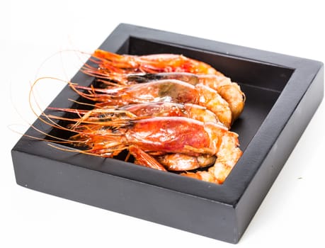 grilled shrimp in a black plate on a white background. selective Focus