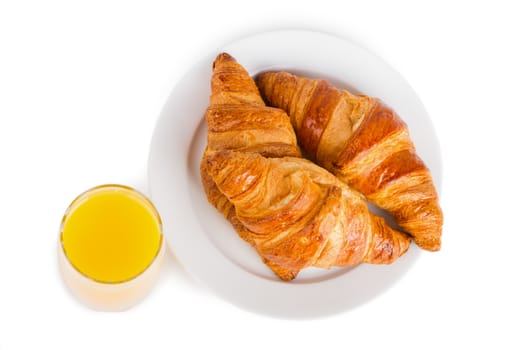 Croissants on a white plate and glass of orange juice. Isolated on white.