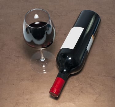 red wine bottle and glass on brown golden background