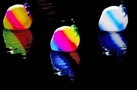 
Three illuminated buoys in a pitch-black night.