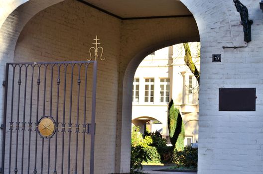 Old gate with drive-through to a beautiful backyard of a hospital.