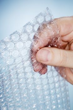Man holding a piece of bubble wrap in his hand.