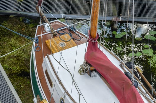 Old wooden sailboat, detail plan view, firmly moored at the berth.