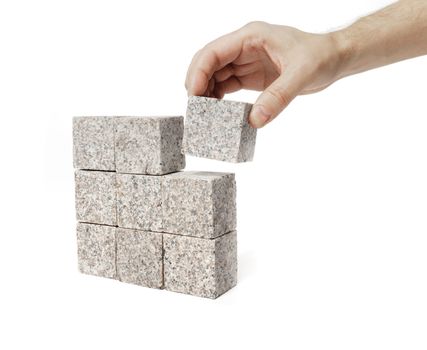 Man making a square shape of blocks made of granite rock.