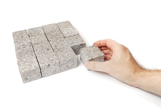 Man making a square shape of blocks made of granite rock.