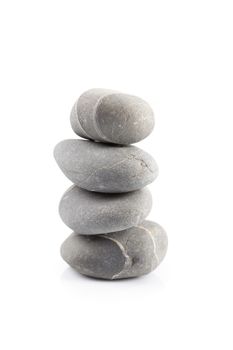 Pyramid of stones over white with reflection shadow