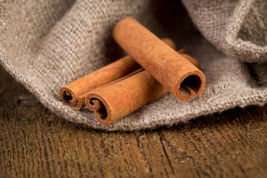 cinnamon sticks on hessian canvas with wooden background