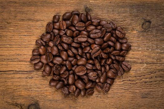 Coffee beans on grunge wooden background. Fresh Roasted coffee beans on vintage table