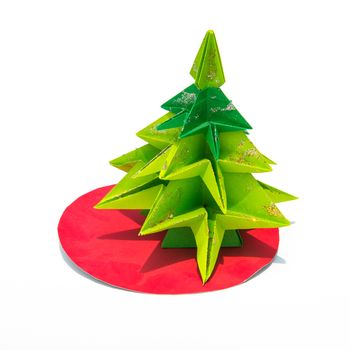 Green origami christmas tree isolated on white background