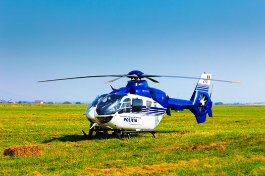 Brasov, Romania - August 12, 2010: Police helicopter on a green grass field preparing to take off