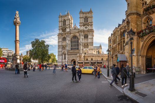 LONDON - OCTOBER 5, 2014: Westminster Abbey on October 5, 2014 in London. Westminster Abbey is a large gothic church and the traditional place of coronation for English monarchs and tourists walking in front of the gate.