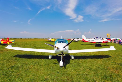 Brasov, Romania - August 12, 2010: White airplane on a green grass field preparing to take off for a flight show