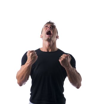 Young Angry Muscled Man, Shouting with Closed Fists, in Plain Black Shirt, Isolated on White Background.