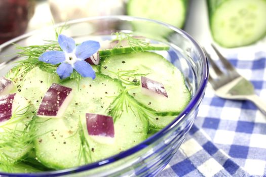 Cucumber salad with red onions, borage flower and dill