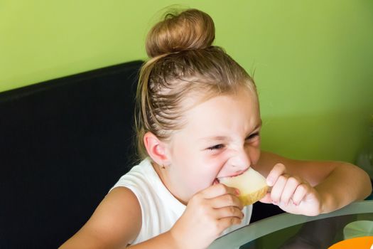 Photo of the cute girl eating melon