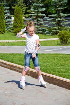 Learning girl on roller skates in summer