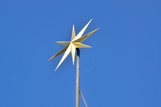 Golden star on a church spire glows in the sun