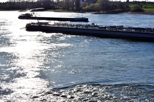 Two Barges at full speed, the evening sun reflected in the fairway.
