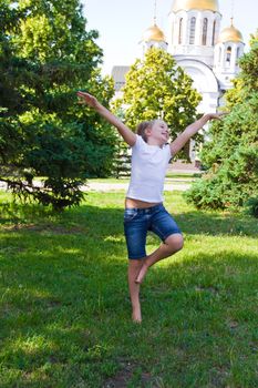Cute girl with blond hair jumping on one leg