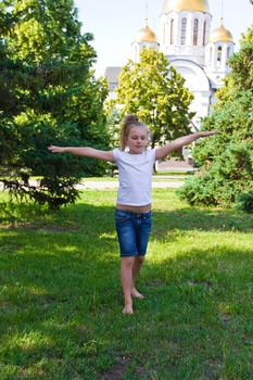 Cute girl with blond hair jumping on one leg