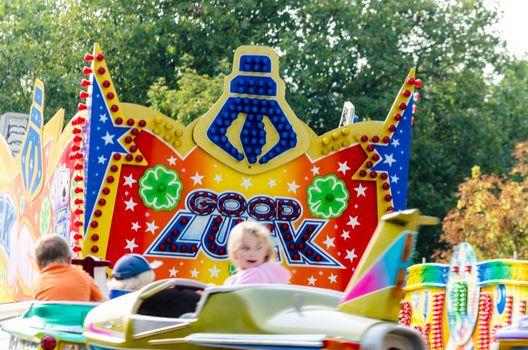 Essen Werden, Nrw, Germany - September 7, 2014: Known September fair, fair in Essen Werden in the parking lot at the church. A group of people, visitors in front of a children's carousel. enjoy the hot late summer day. The name funfair is the abbreviation of the word church weih fair.