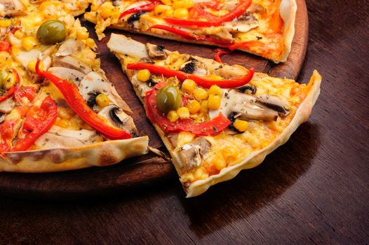 Macro closeup of pizza with mozzarella, mushrooms, olives and red bell pepper