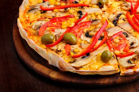 Macro closeup of pizza with mozzarella, mushrooms, olives and red bell pepper