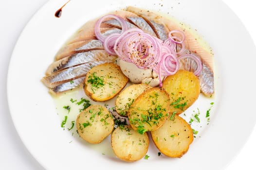 Roast potatoes with salted hering and onion rings