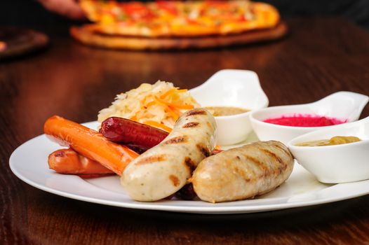 German bawarian roasted sausages with stewed cabbage and sauces