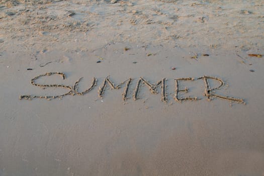 Photo shows a detail of the sign in the beach sand.