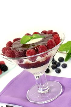 Layered dessert with blueberries and raspberries on a light background