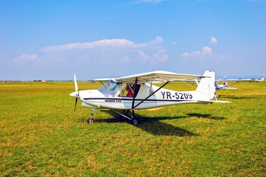 Brasov, Romania - August 12, 2010: White airplane on a green grass field prepared to take off for a flight show