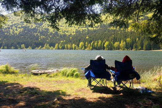 Tourists Couple contemplating on shore St. Ana lake, Romania