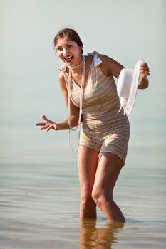 Woman in a striped retro bathing suit posing against the sea
