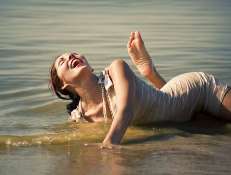 Woman in a striped retro bathing suit enjoy a vacation on the beach