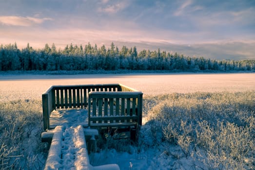 Breathtaking view of a winter forest and a wooden viewpoint                 