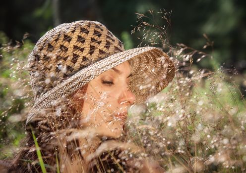 Young woman in the grass on natural background in the sunlight