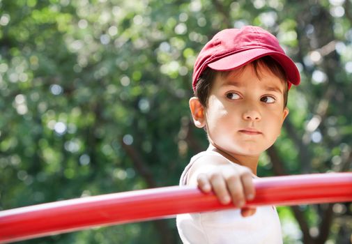 Portrait of a 3-4 years boy playing on the playground in sunny day