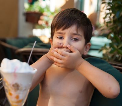 Little boy does not want to eat ice cream dessert