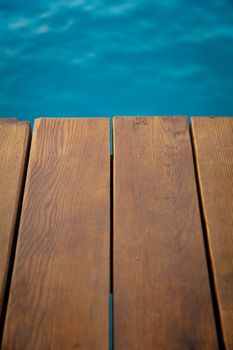 Closeup view of wooden pier with blue sea backdrop